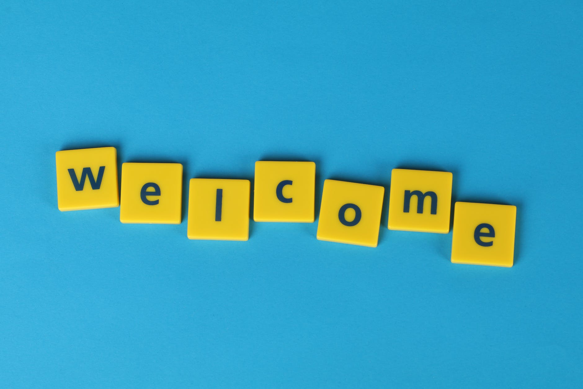 The word welcome spelt out with yellow blocks with a blue background. For welcoming busy female professionals like realtors and real estate agents to this Faith and self-care/skincare blog