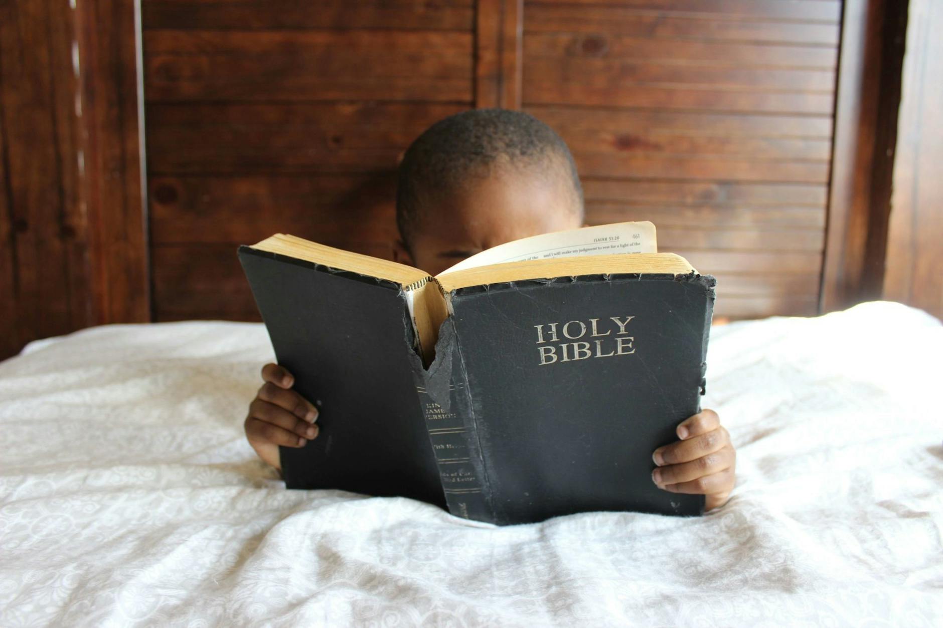 child reading the bible. Capital Femme faith-based self-care/skincare. Christian skincare. Glow with faith. 1 Corinthians 6:19-20. Busy professional women. Realtors and real estate agents. Clean skincare.