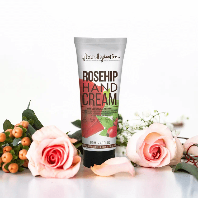 Capital Femme with Urban Hydration Rosehip Hand cream with flowers (pink roses) around it. Clean skincare product for dry hands and busy, professional women.
